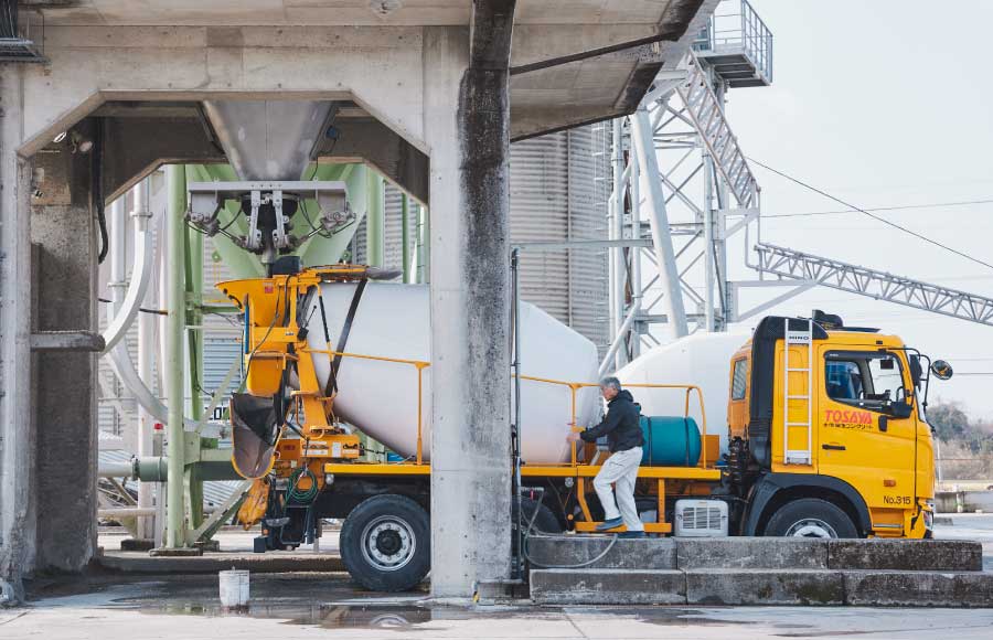 生コンプラントでミキサー車に生コンクリートを積み込む作業風景