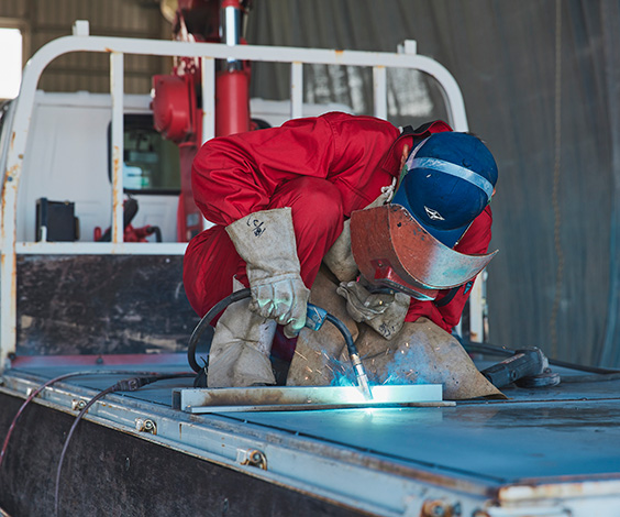 整備工場内でトラックの架装・鈑金塗装を行っている作業風景